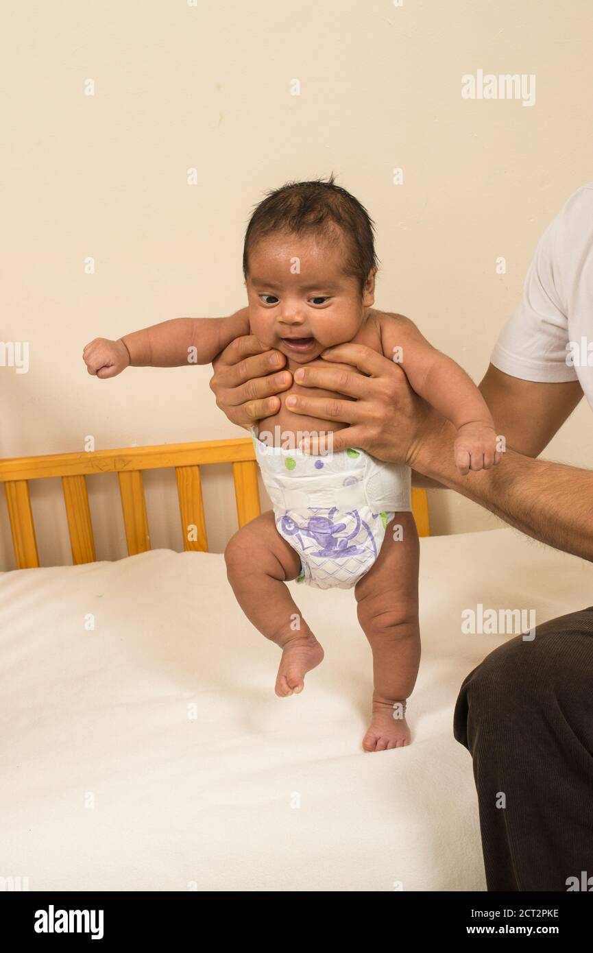 6 Wochen alter neugeborener Junge aufrecht gehalten vom Vater, Reflex: Treten, Gehen Bewegung, wenn aufrecht gehalten mit Gewicht auf Fußsohle Stockfoto