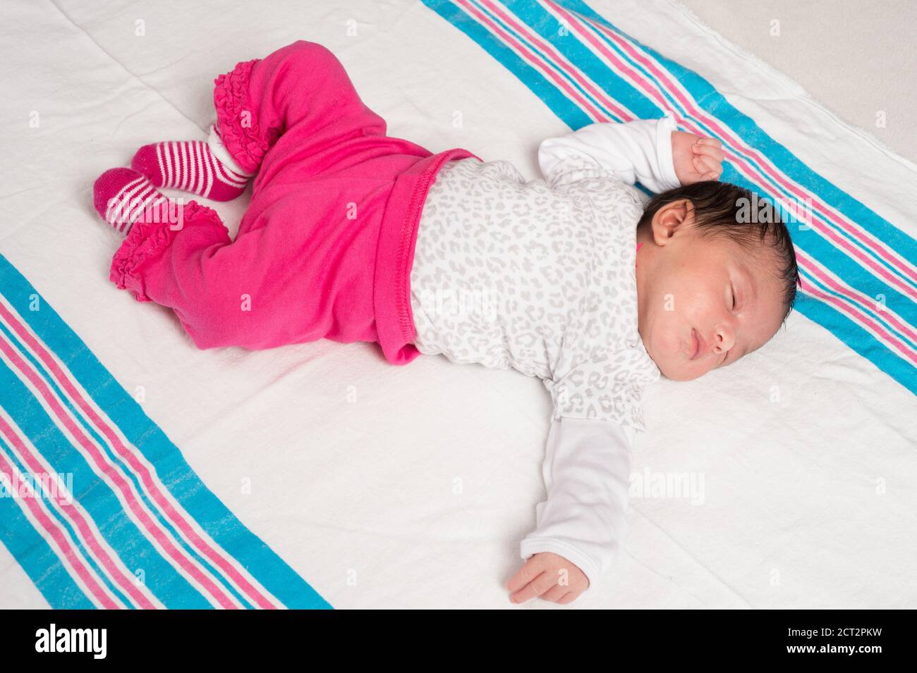 10 Tage altes neugeborenes Baby Mädchen auf dem Rücken voller Länge schläfrig Reflex Tonic Hals Fencing Reflex, liegend auf Empfangs Decke Stockfoto