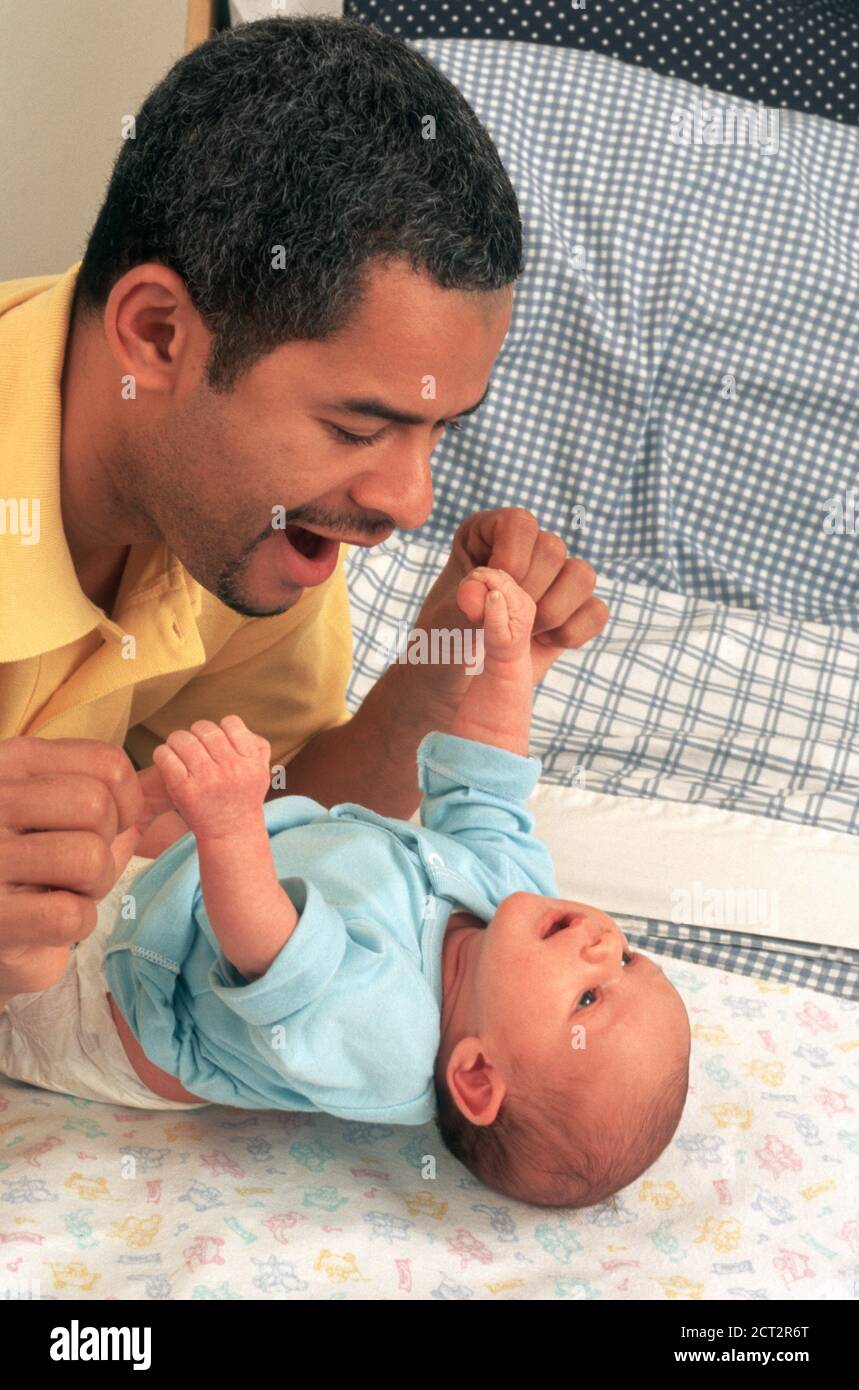 Neugeborener Junge 2 Wochen alt mit Vater Palmar greifen Reflex Griff angehoben aus dem Bett hält die Finger des Vaters biracial Hispanisch dominikanisch weiß Stockfoto