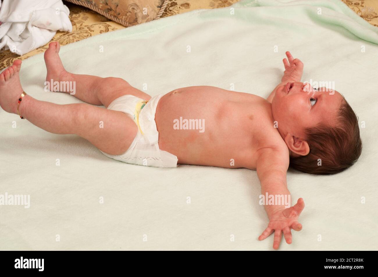 1 Monat altes neugeborenes Baby Mädchen auf dem Rücken in Windel, Reflexerschreckerschreckes (Moro Reflex) Stockfoto
