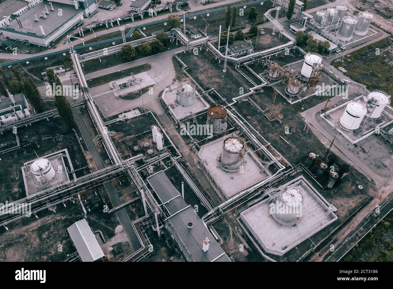 Dunkle industrielle Landschaft Hintergrund von oben. Petrochemische Fabrik mit Rohrleitungen und Stahltanks, Luftaufnahme. Stockfoto