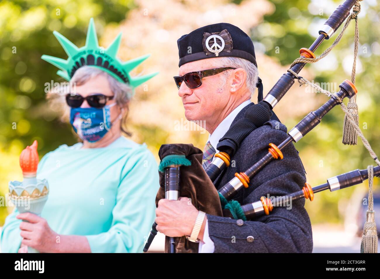 Frau gekleidet als Freiheitsstatue mit Dudelsackspieler bei der Kundgebung, um das Leben, Vermächtnis und die Mission des Obersten Gerichtshofs Ruth Bader Ginsburg zu ehren. Stockfoto