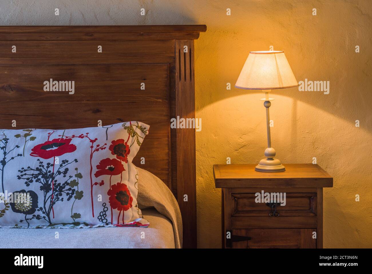 Schlafzimmer Haus Interieur mit einem roten Blumenmuster Kissen, Holzbett, Nachttisch und Lampe in einem Luxushotel, Mendoza, Provinz Mendoza, Argentinien, Südamerika Stockfoto