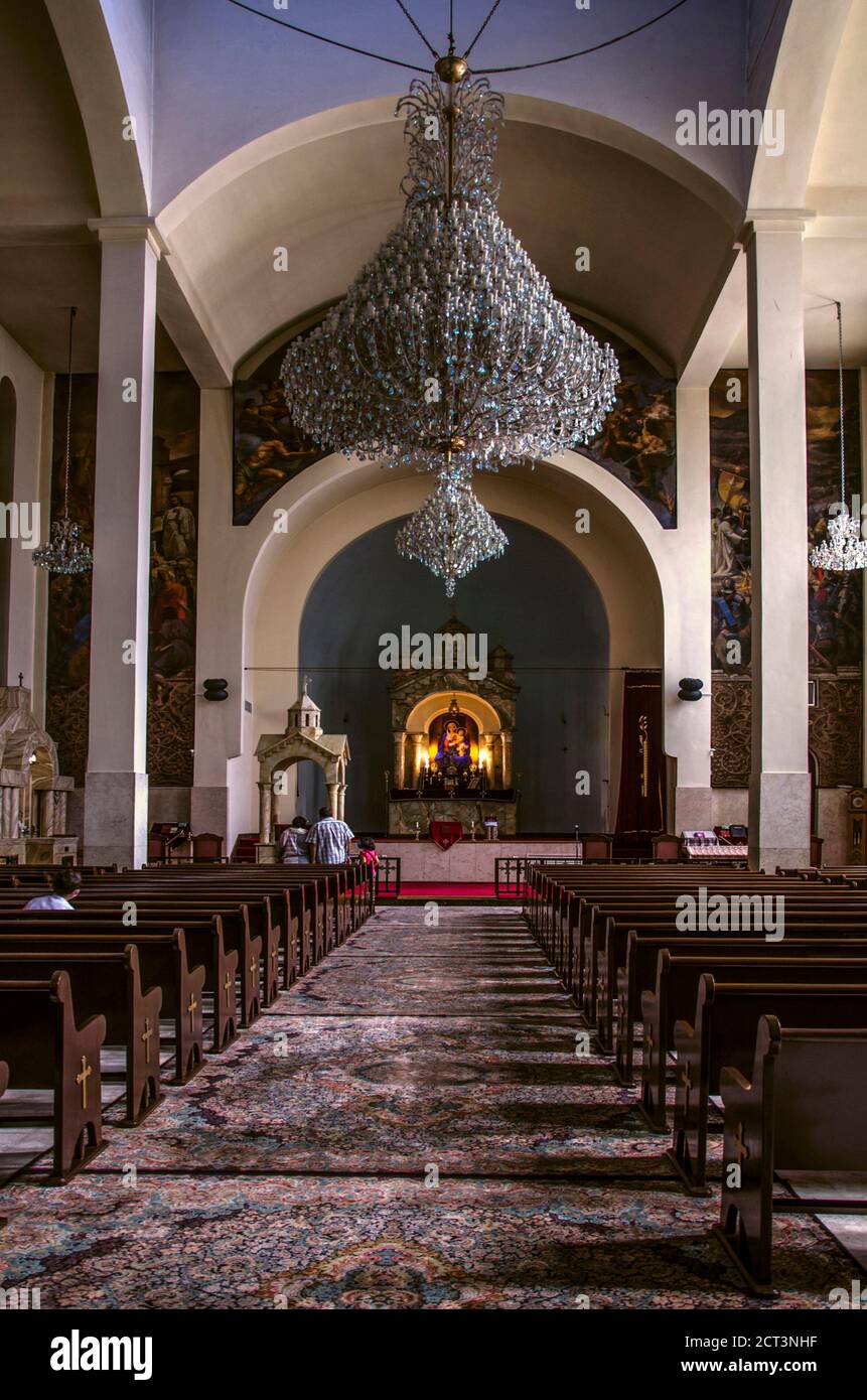 Teheran,Iran,27. August,2020:Saal mit Sitzbänken für Gemeindemitglieder, Altar mit Ikone der Jungfrau, Kristallleuchter, unter der gewölbten Decke Stockfoto