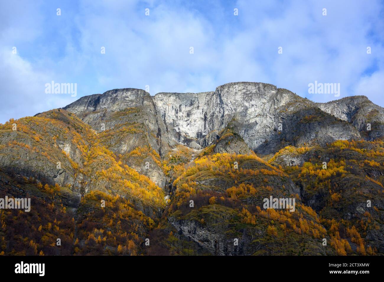 Die großen felsigen Berge auf der Spitze des Berges sind schneeweiß und blauen Himmel mit Wolken und die Blätter werden gelb in der Herbstsaison. Stockfoto