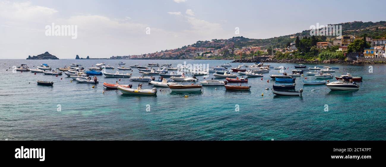Panoramafoto von Booten im Hafen von Aci Trezza mit Isole dei Ciclope im Hintergrund, etwas außerhalb von Catania, Sizilien, Italien, Europa Stockfoto