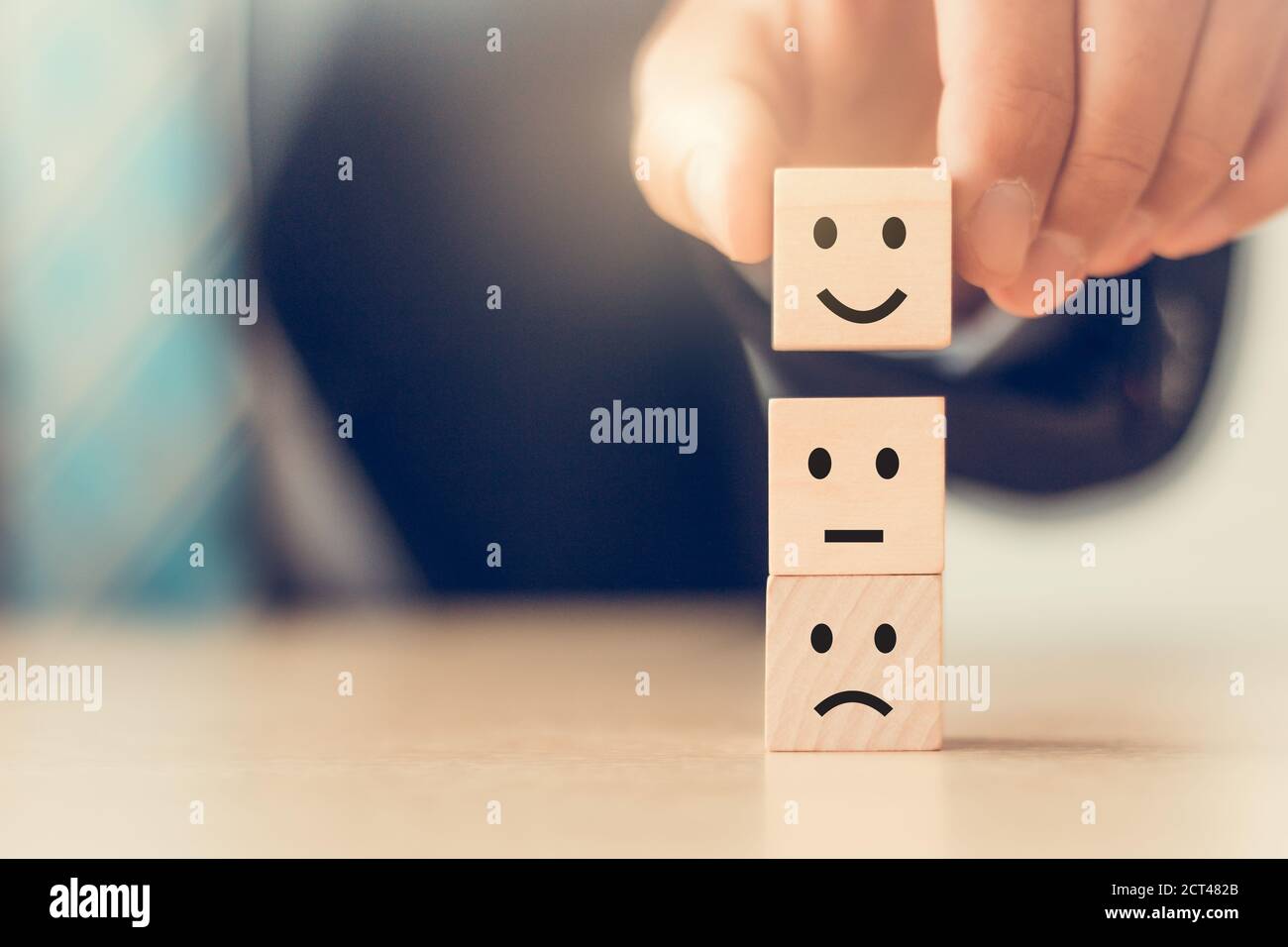 Business man Hand Arrangieren Holzblock Würfel und wählen Smiley Gesicht Symbol, Kundendienst Zufriedenheit Konzept Stockfoto