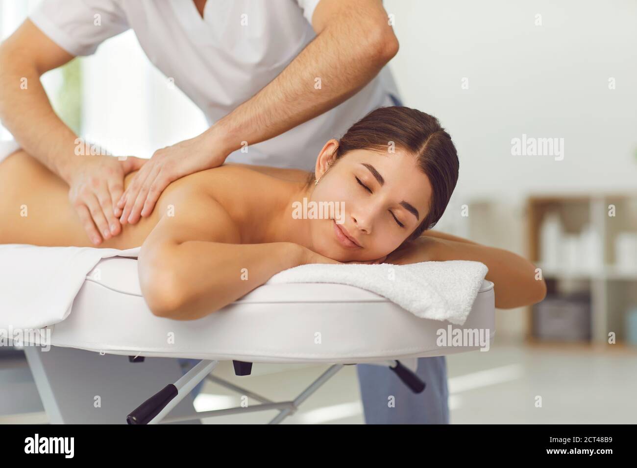 Entspannte Frau genießen Rückenmassage von professionellen Masseur oder getan Physiotherapeut im Gesundheitszentrum Stockfoto