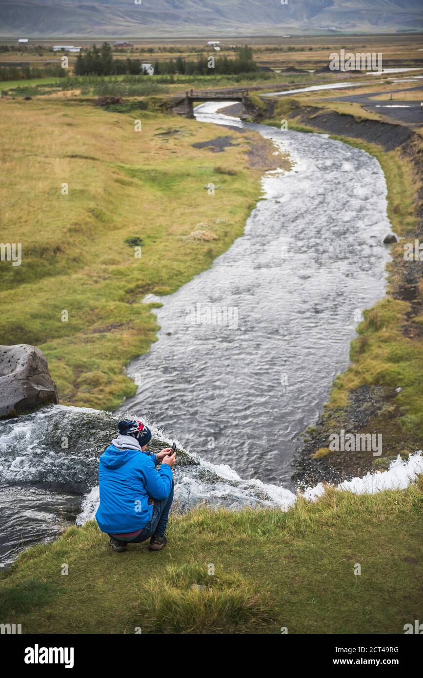 Touristen, die ein Foto machen bei Gluggafoss (Window Falls aka Merkjarfoss), einem Wasserfall auf dem Merkja Fluss, Südisland (Sudurland), Europa Stockfoto