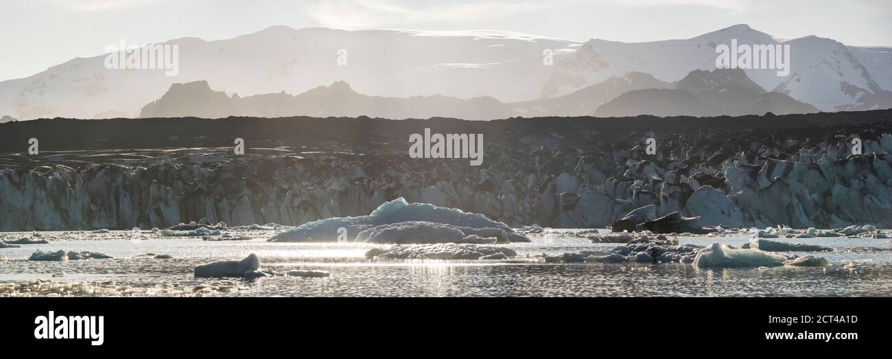Schmelzgletscher und Eiskappe durch Klimawandel und globale Erwärmung, mit Eisbergen in der Jokulsarlon Lagune bei Sonnenuntergang, mit Breidamerkurjokull Gletscher dahinter, Südostisland, Europa Stockfoto