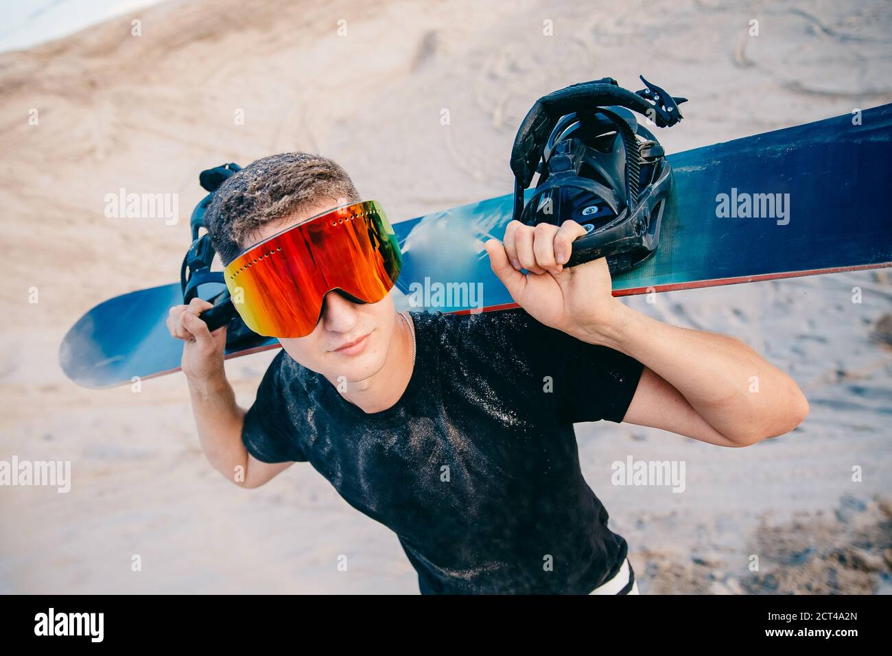 Snowboarder Mann Sand Boarding auf Dünen in Dubai, VAE Stockfoto