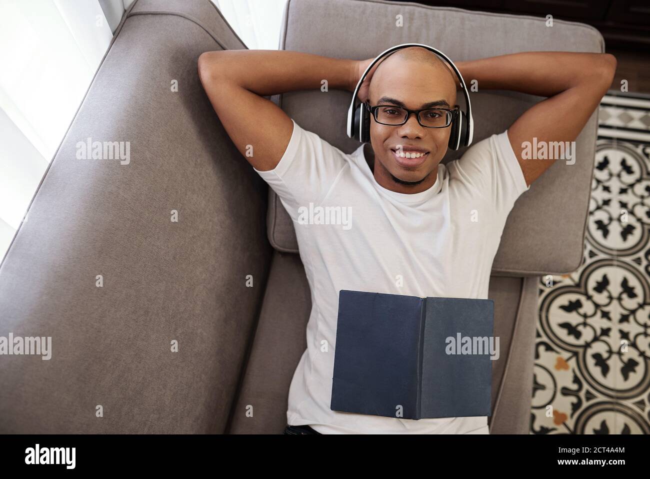 Schwarzer Mann, der sich auf dem Sofa entspannt Stockfoto
