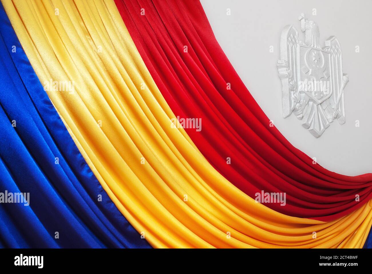 Moldauische Flagge mit Fokus auf weißem Gips Wappen Büste an der weißen Wand Stockfoto
