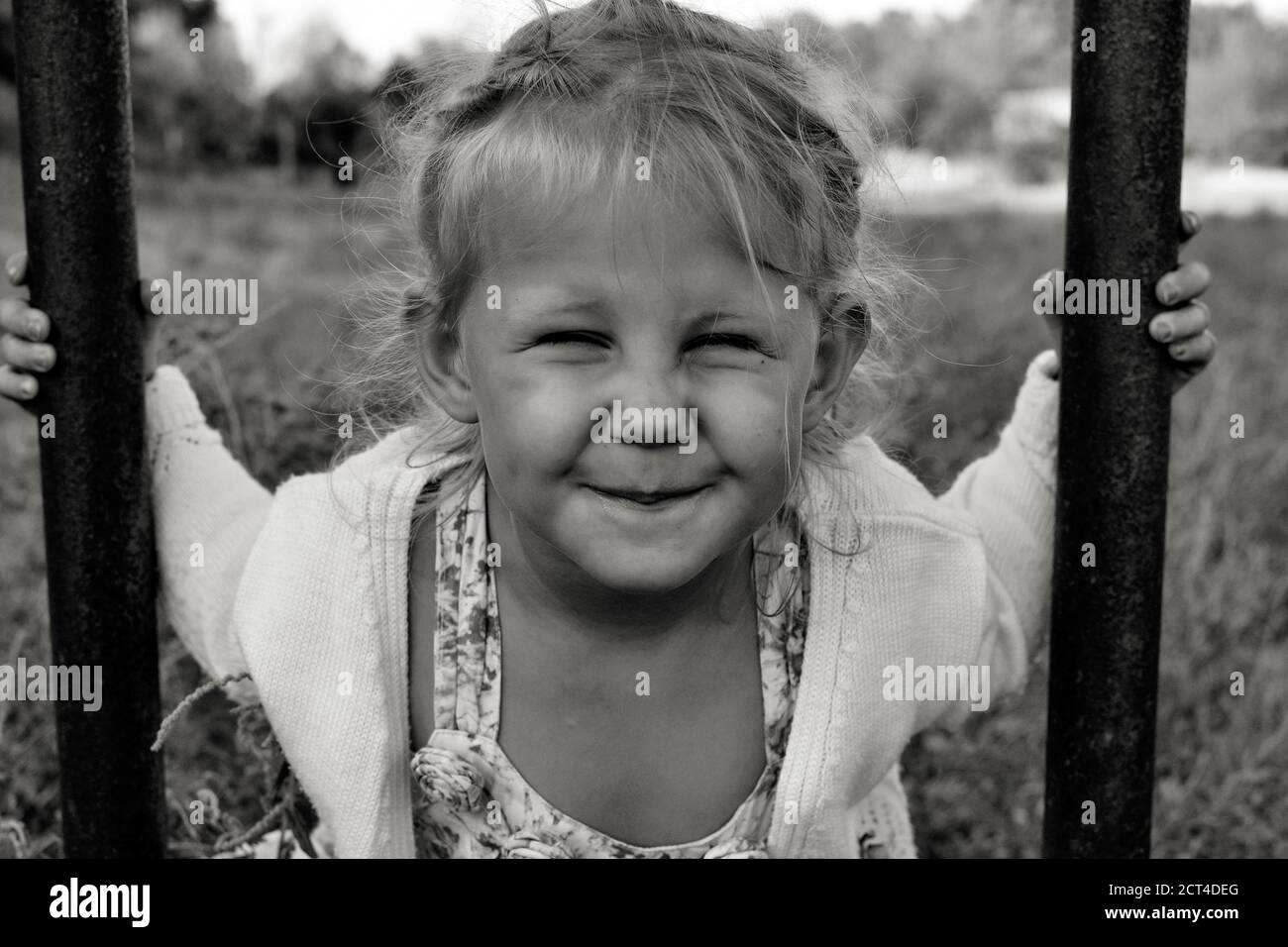 Nahaufnahme schwarz-weiß Porträt von niedlichen liebenswert lächelnd kaukasischen Kind. Porträt eines glücklichen Kindes in der Natur. Happy Childhood Konzept. Das Baby Stockfoto