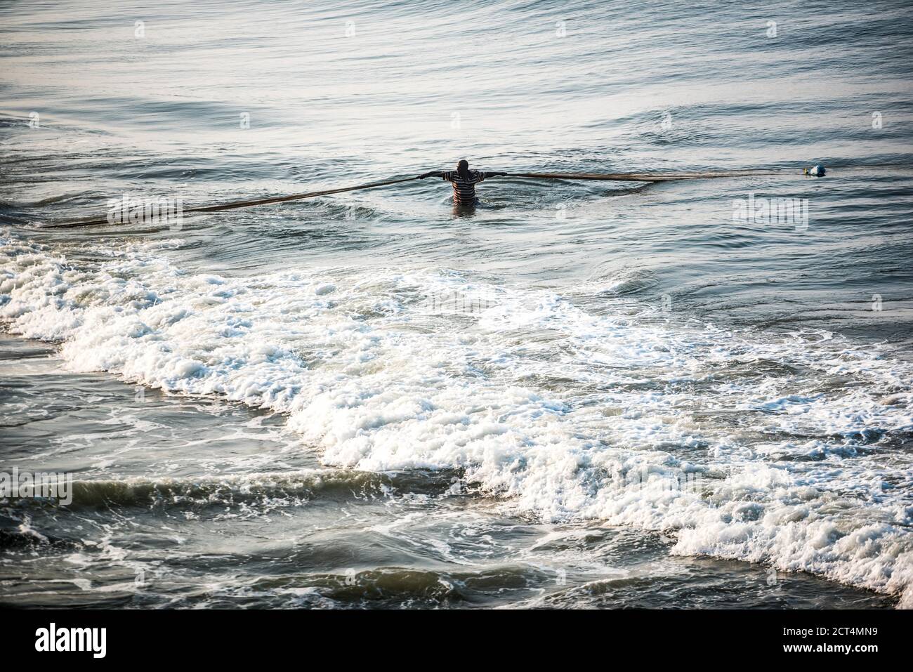 Fischer ziehen große Fischernetze in den Wellen am Kappil Beach, Varkala, Kerala, Indien Stockfoto