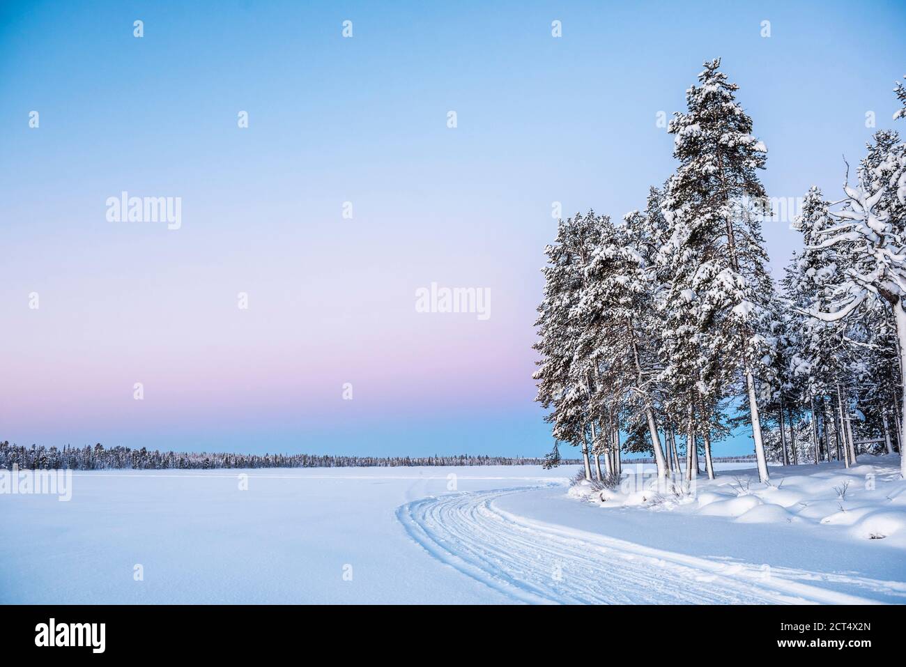 Gefrorener schneebedeckter See in der Winterlandschaft in Lappland Bei Sonnenuntergang im Polarkreis in Finnland Stockfoto
