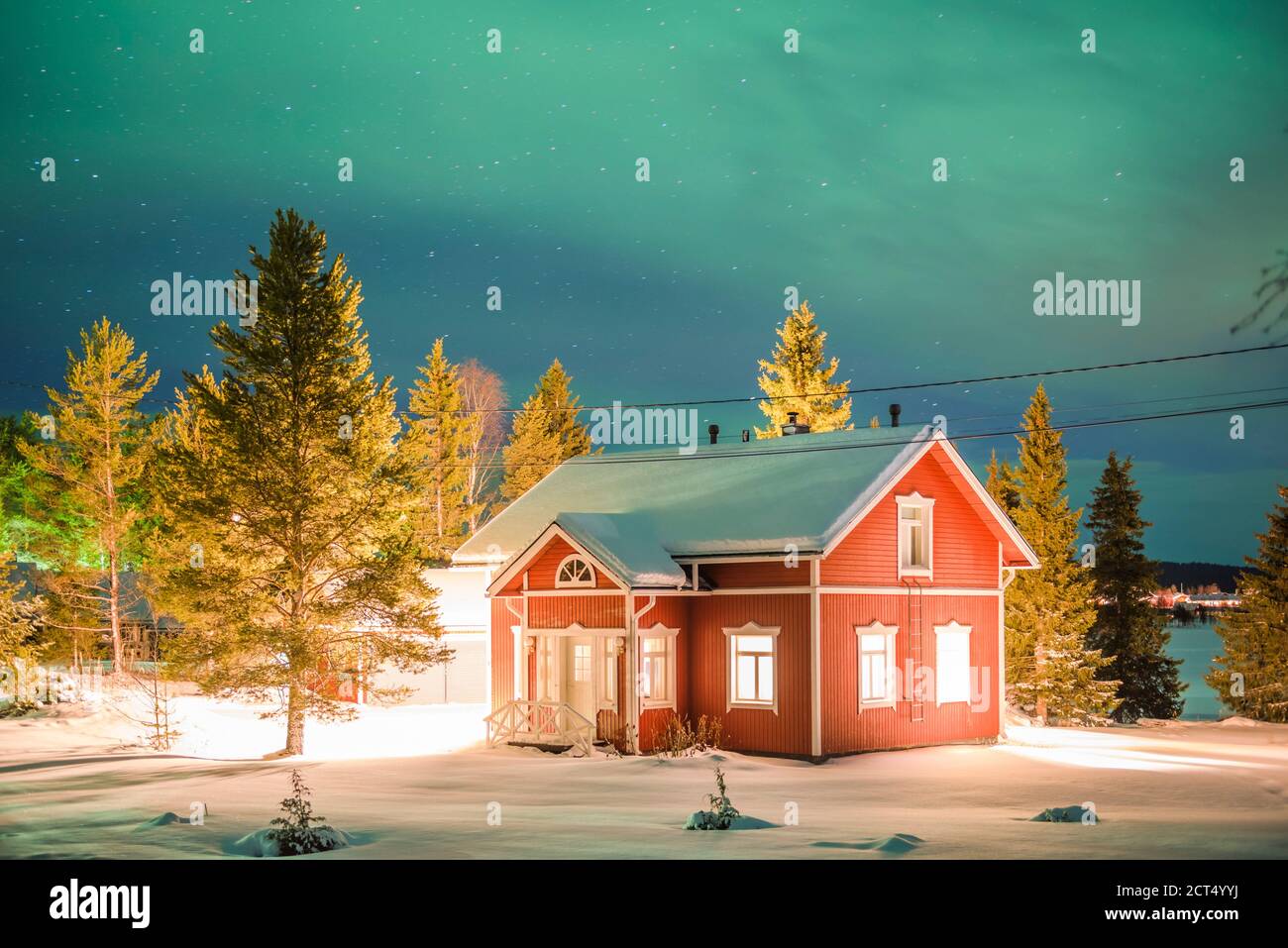 Nordlichter (aurora borealis) über traditionellen skandanavianischen Häusern im Dorf Akaslompolo, einer kleinen Stadt in Finnisch-Lappland, am Polarkreis in Finnland Stockfoto