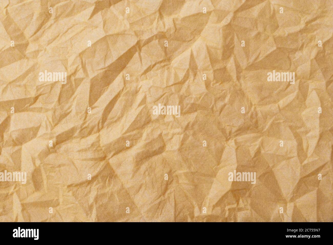 Die Textur einer zerknitterten gelb-goldenen Einweg-Textilserviette. Stockfoto