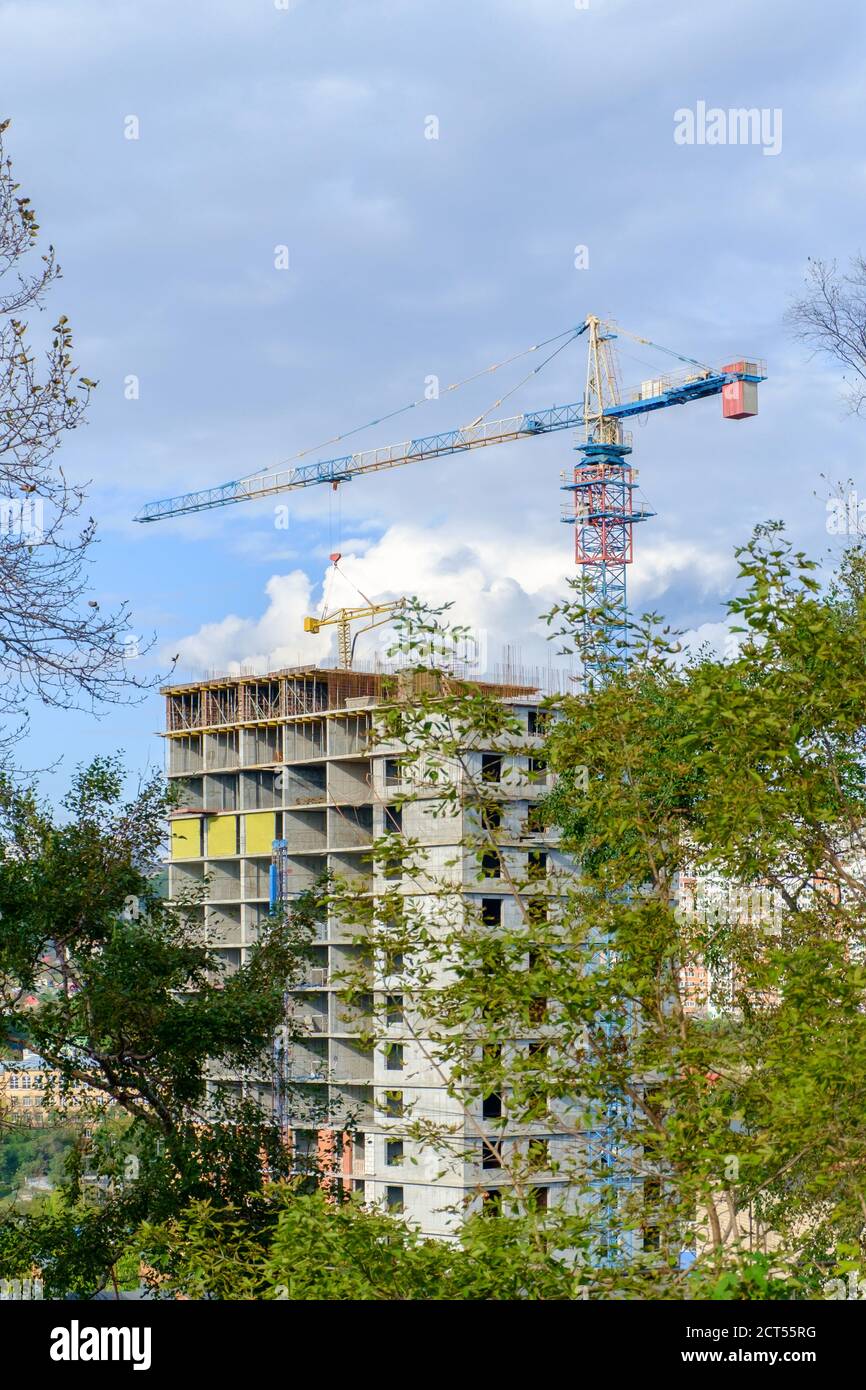 Bau eines mehrstöckigen Gebäudes. Hochhaus Baukran gegen einen blau bewölkten Himmel. Selektiver Fokus. Stockfoto