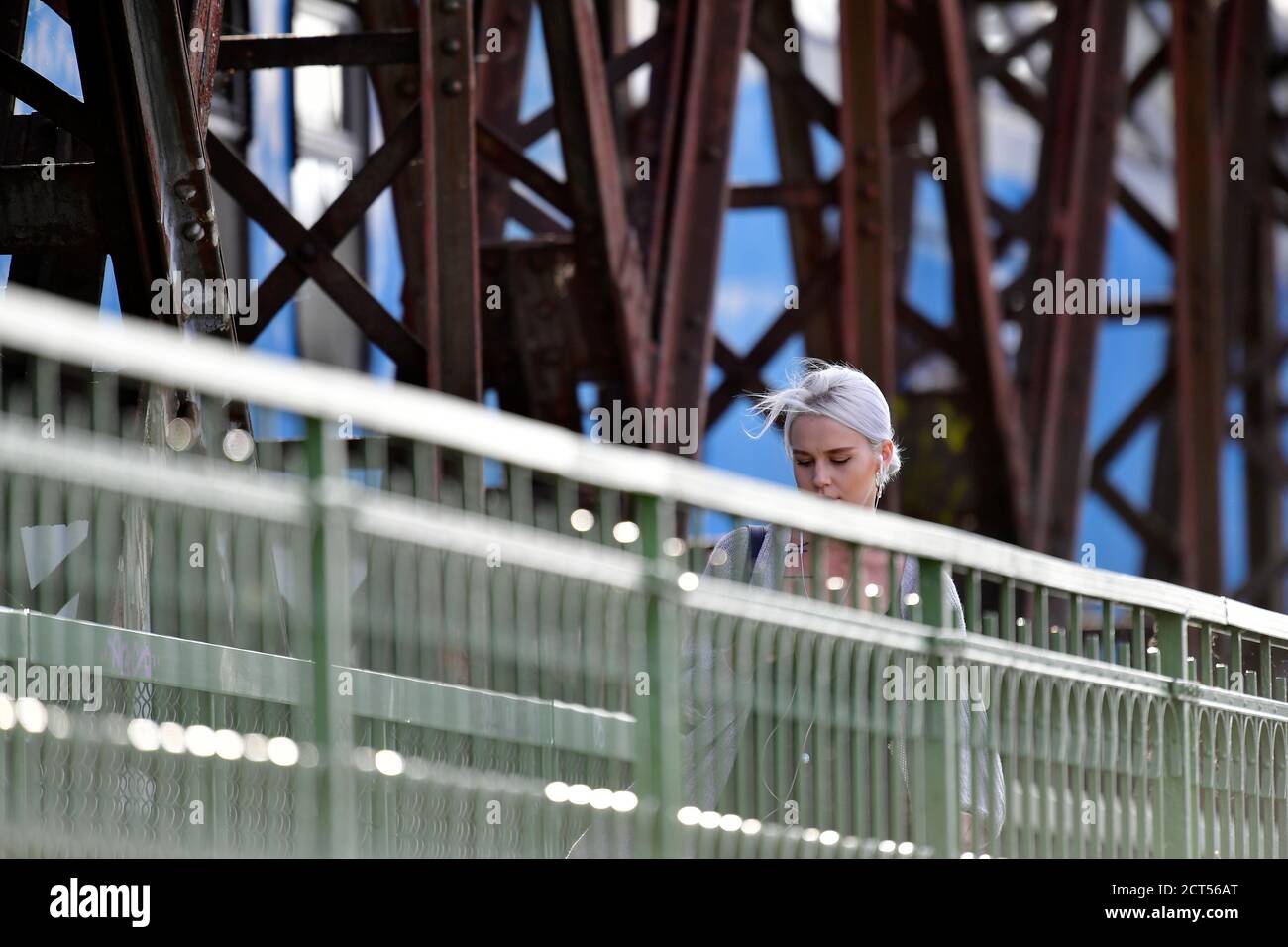 Ein blondes Mädchen, das über die Brücke läuft Stockfoto