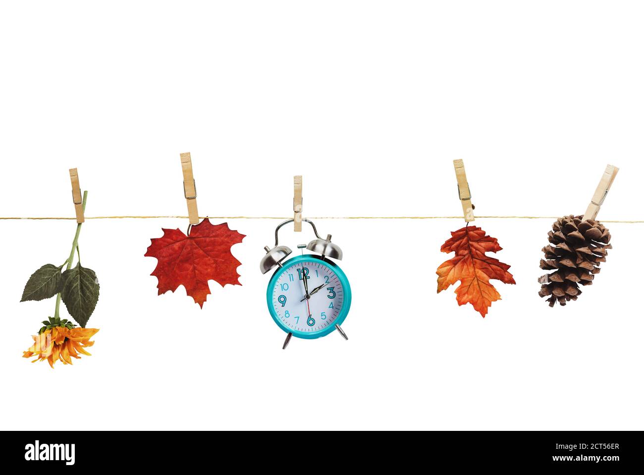 Stellen Sie Ihre Uhren zurück mit dieser Uhr, Blume, Herbstblätter und und Kiefer Kegel hängen an Kleidung Pins an einer Wäscheleine über einem weißen Hintergrund. Tagli Stockfoto