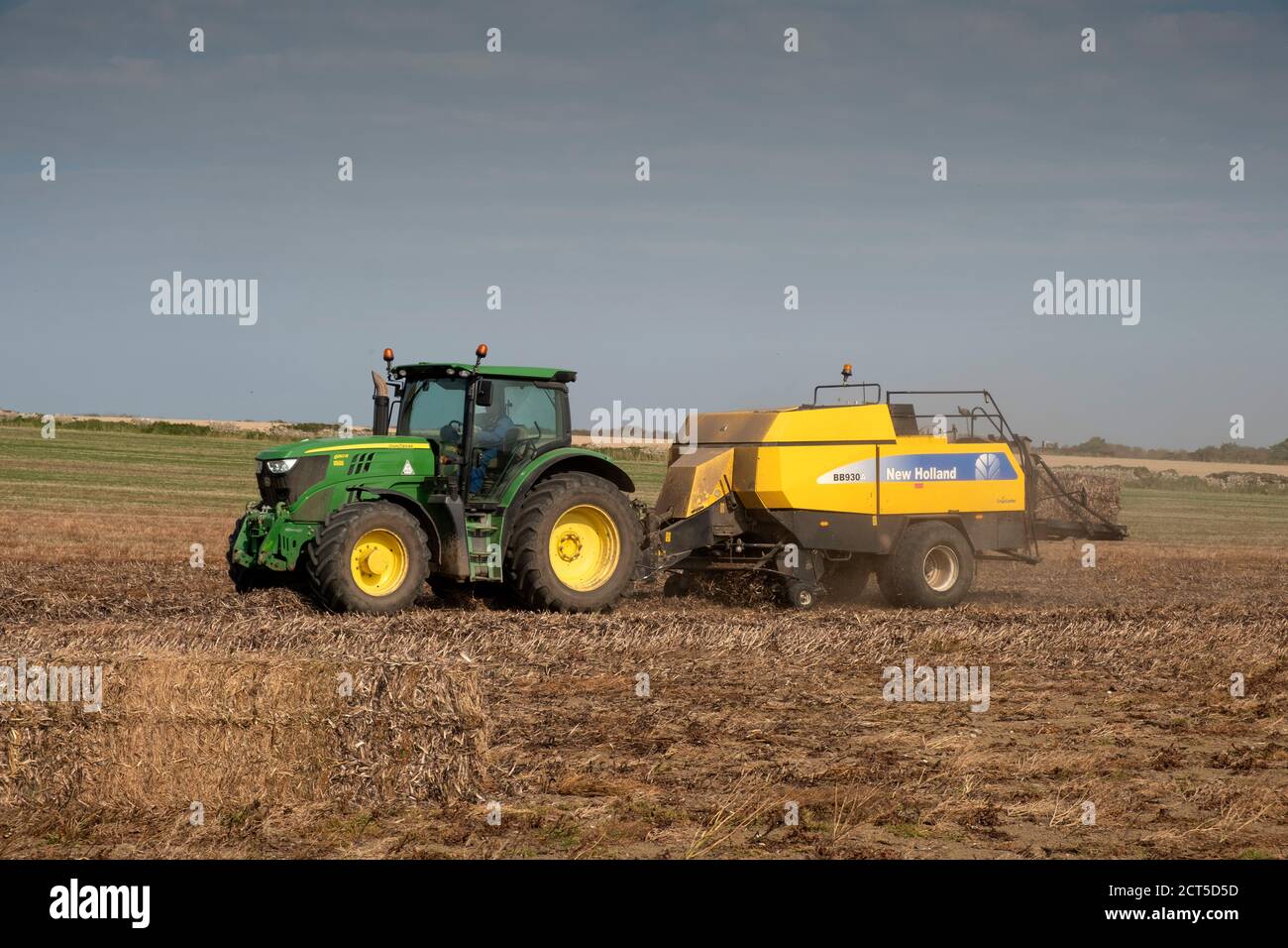 Traktor und Ballenpresse bei der Arbeit in South Wales, Großbritannien Stockfoto