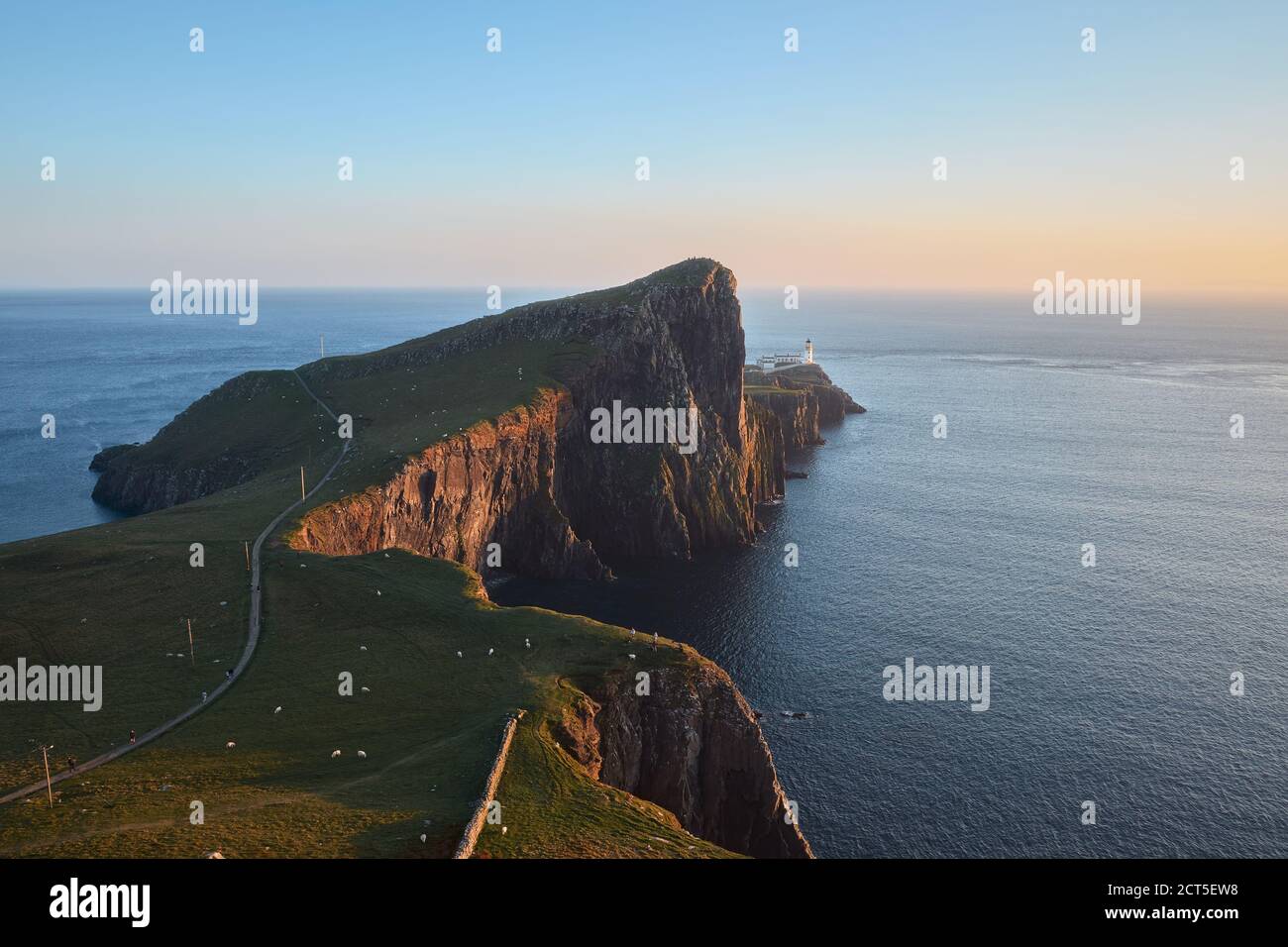 Eine Landschaft eines feinen Leuchtturms, der auf einer atemberaubenden Klippe vor der Kulisse des Meeres und des Sonnenuntergangshimmels steht. Neist Point, Isle of Skye, Schottland. Stockfoto