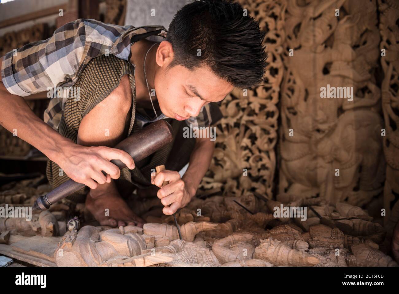 Holzschnitzerei, ein Zimmermann arbeitet an einer Statue, Mandalay, Mandalay Region, Myanmar (Burma) Stockfoto