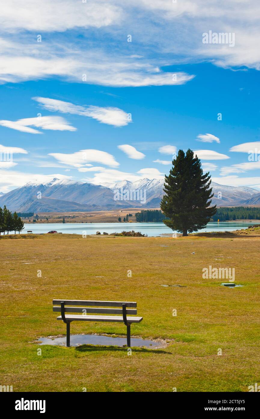 Parkbank mit einem fantastischen Blick auf schneebedeckte Berge am Lake Tekapo, Südinsel, Neuseeland Stockfoto