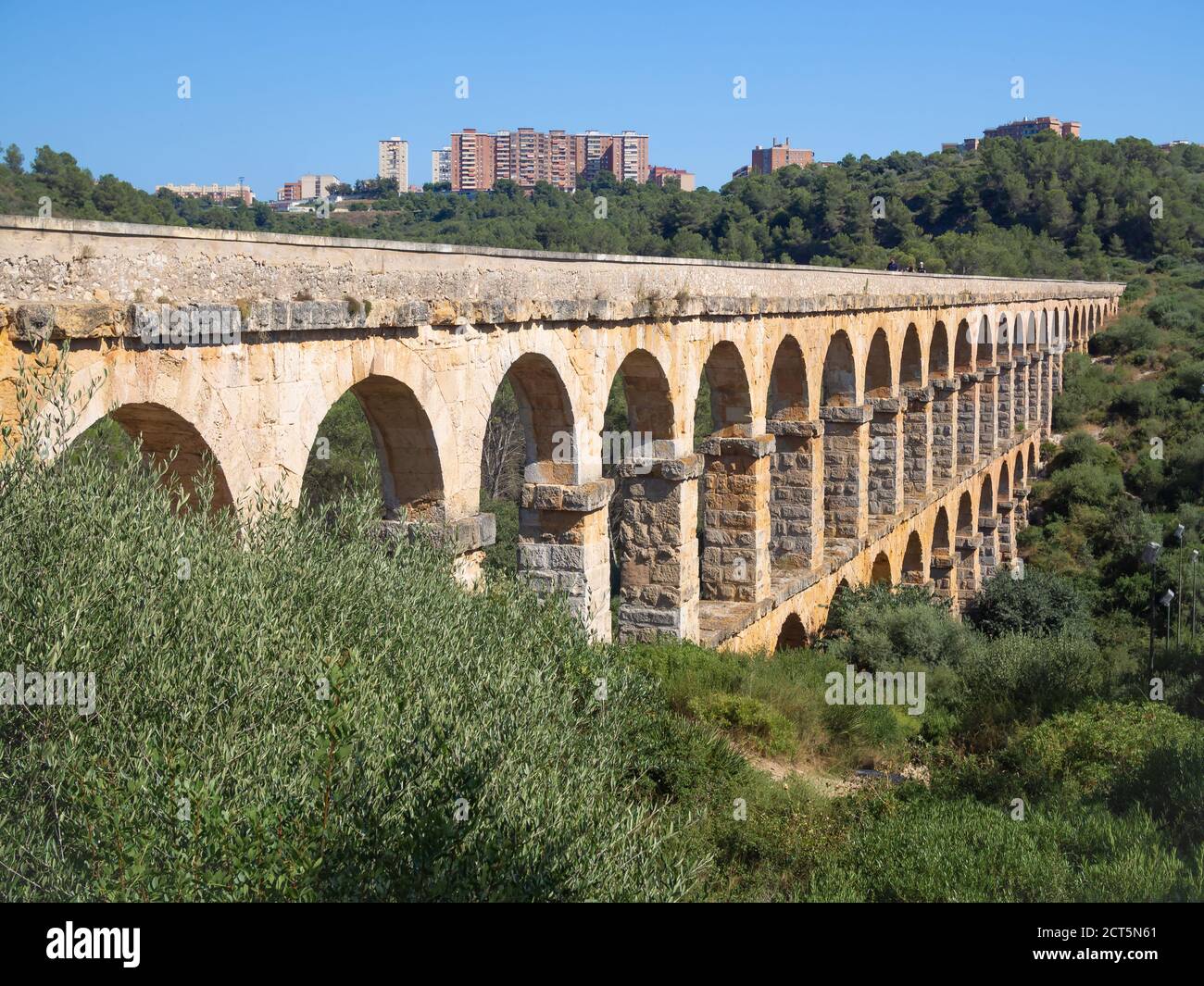 Antikes römisches Aquädukt, bekannt als El Pont del Diable (Teufelsbrücke) und die Wohnhäuser am Horizont in Tarragona, Katalonien, Spanien. Stockfoto