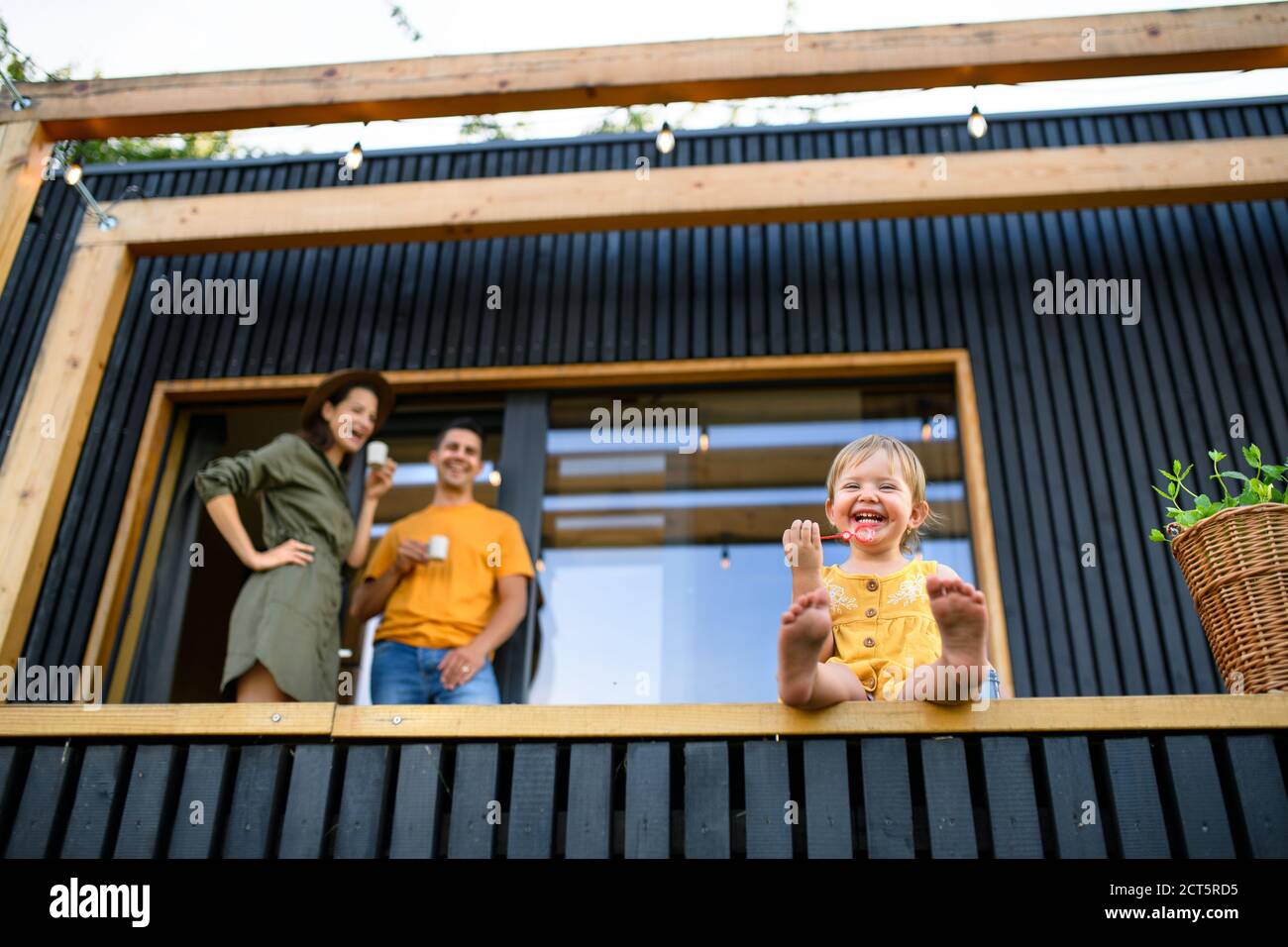 Low-Winkel-Ansicht der Familie mit kleiner Tochter im Freien, Wochenende in Container-Haus auf dem Land. Stockfoto