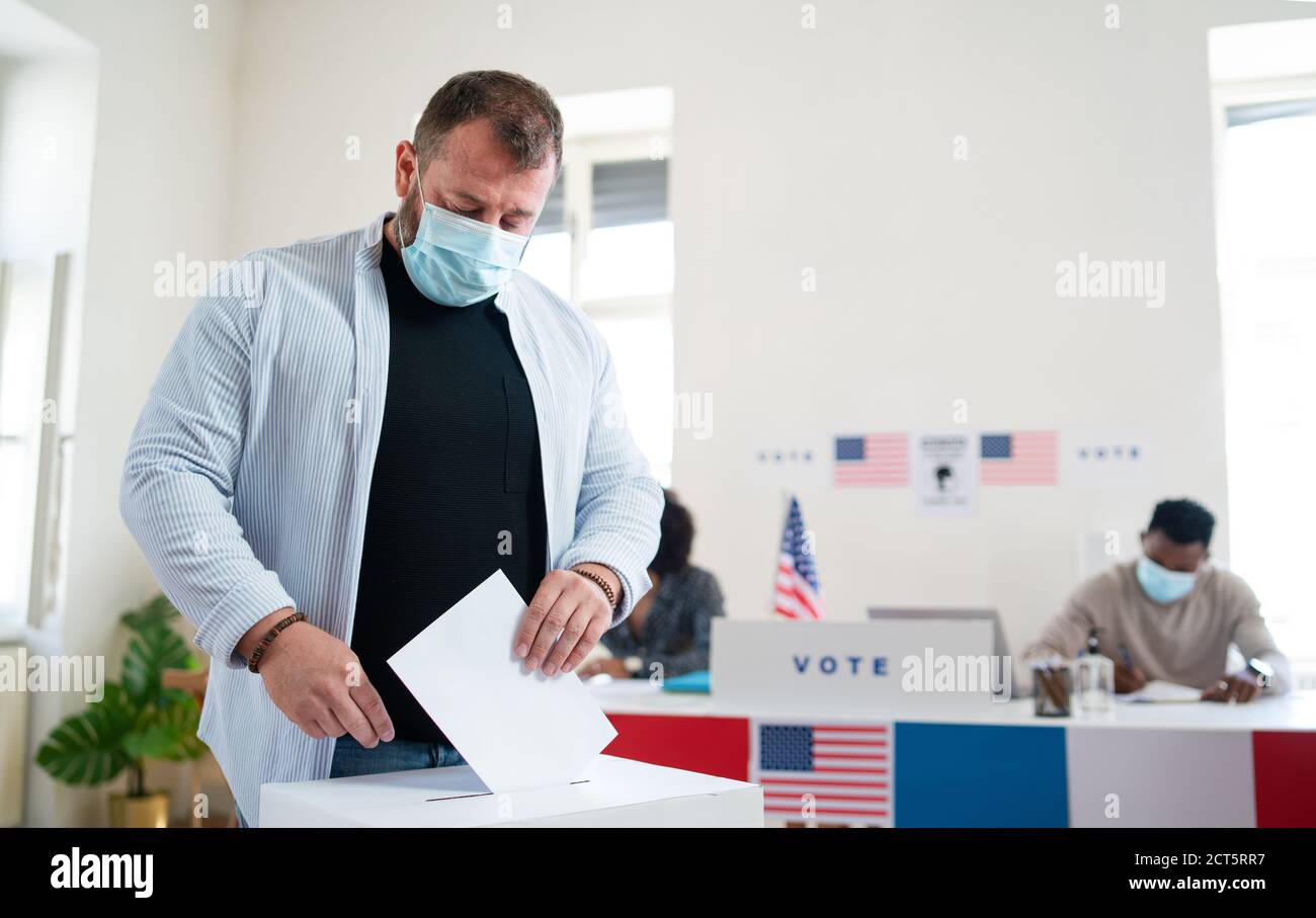 Reifer Mann, der seine Stimme in die Wahlurne legt, USA-Wahlen und Coronavirus. Stockfoto