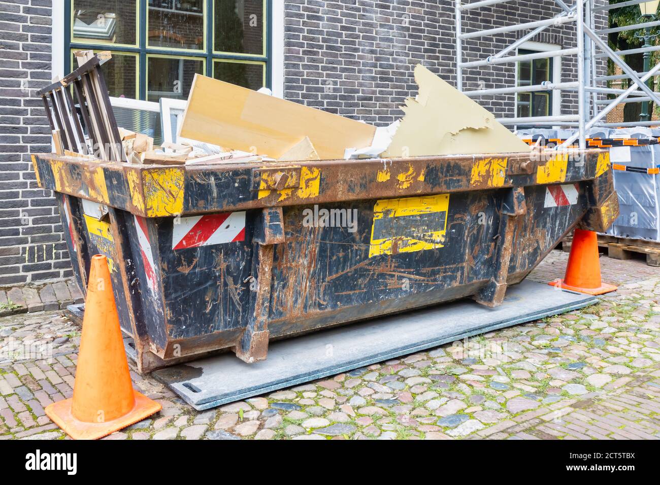 Holländischer Abfallcontainer in einer alten Straße auf einem Haus Renovierung Baustelle Stockfoto