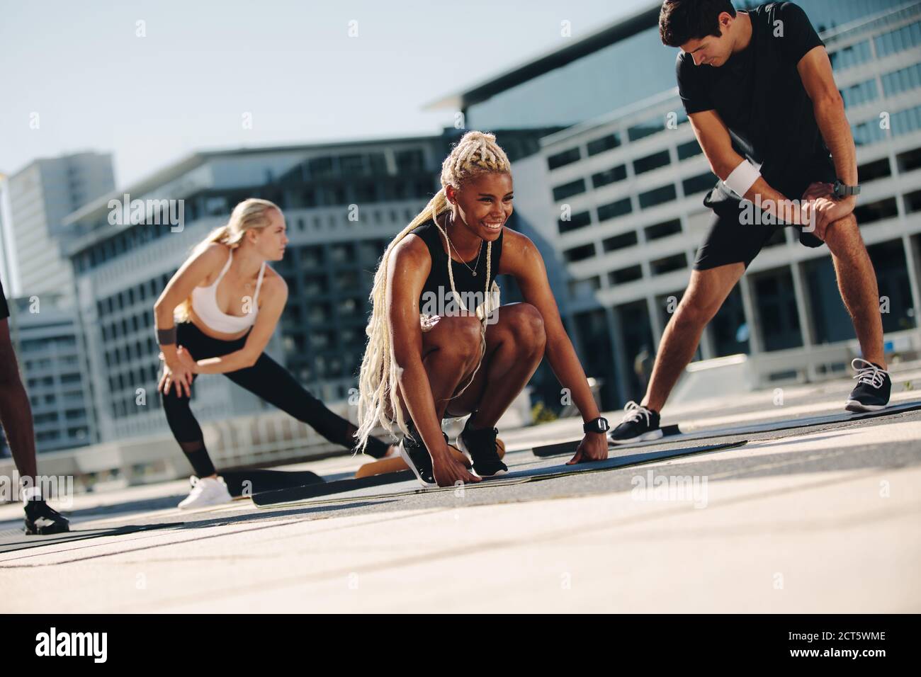 Gruppe von Menschen gemeinsam trainieren im Freien in der Stadt. Multi-Ethik Männer und Frauen in Sportbekleidung tun Stretching-Training. Stockfoto