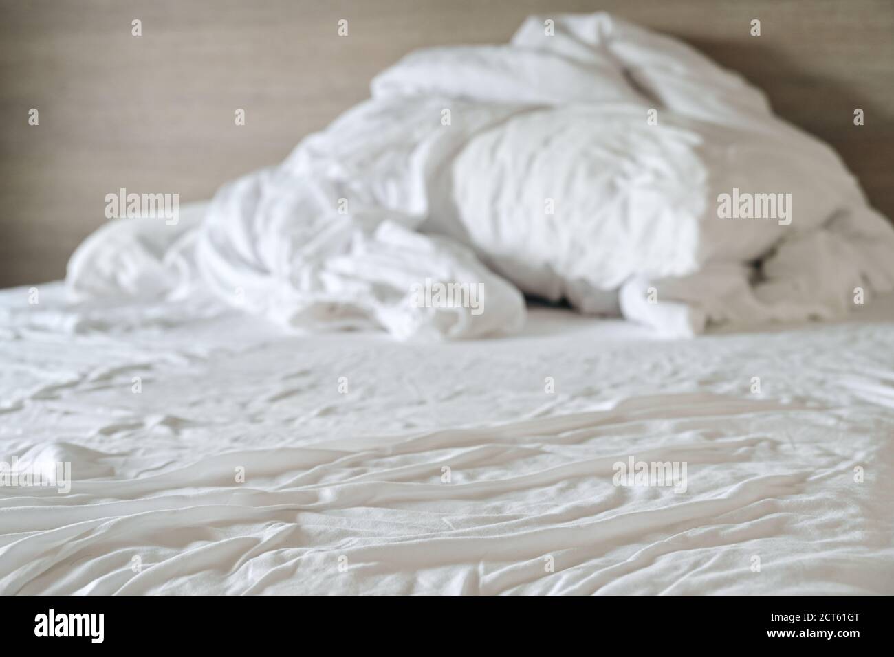 Nahaufnahme von ungeschaufeltem Bettlaken im Schlafzimmer nach der Nacht Schlaf, weiße faltige fabic Textur gewellte Oberfläche Stockfoto