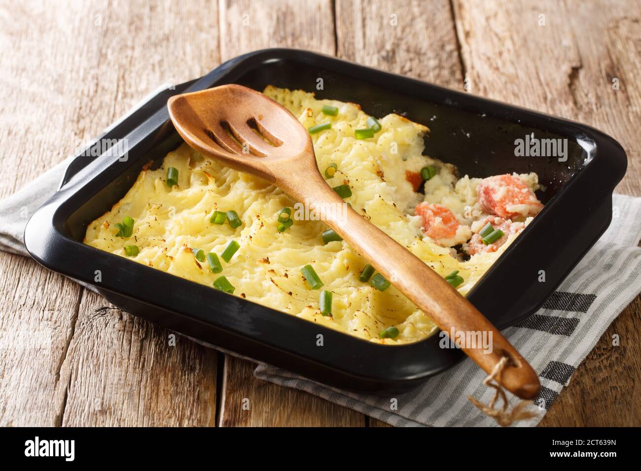 Fish Pie, auch bekannt als Fisherman's Pie, ist ein traditionelles britisches Gericht Pie aus Kartoffelpüree und Lachs Nahaufnahme in einer Backform auf dem Tisch. Stockfoto