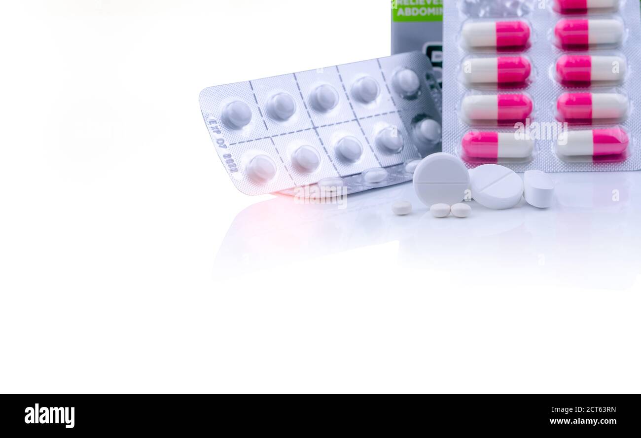 Weiße Tabletten Pillen auf weißem Tisch und verschwommen rosa-weiße Kapsel Pillen in Blisterpackung. Pharmazeutische Produkte. Pharmaindustrie. Runde und Stockfoto