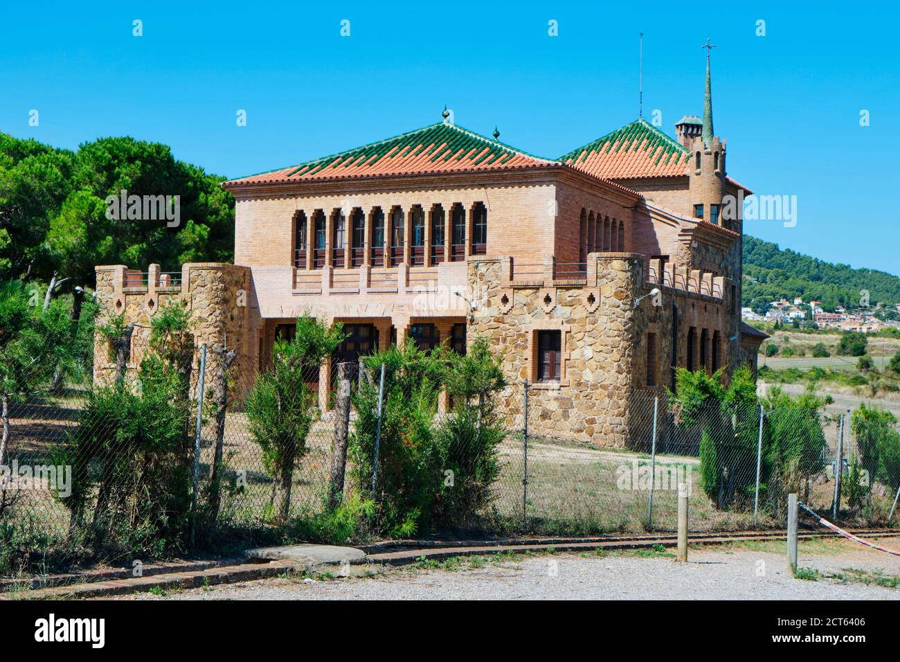 Das Schulgebäude in der Colonia Guell in Santa Coloma de Cervello, Spanien, das im Hintergrund an das Gebäude Casa del Mestre angeschlossen ist, wurde in beiden Gebäuden gebaut Stockfoto