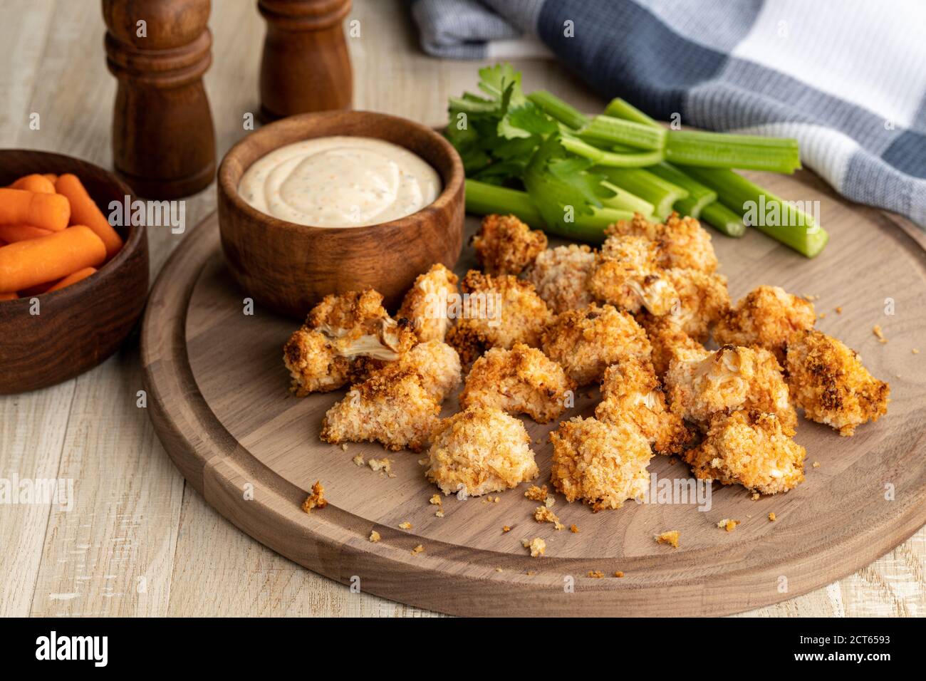 Knusprige Luft gebratene Blumenkohlröschen und Ranch Dip mit Sellerie auf einem Holztablett Stockfoto