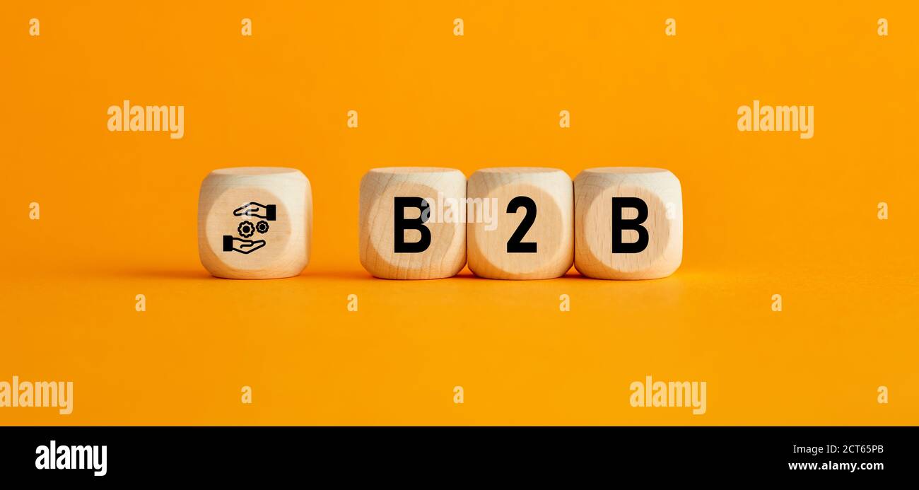 Die Abkürzung B2B Business to Business on wooden cubes with on yellow background. Geschäftstransaktion und Corporate Partnership Konzept. Stockfoto