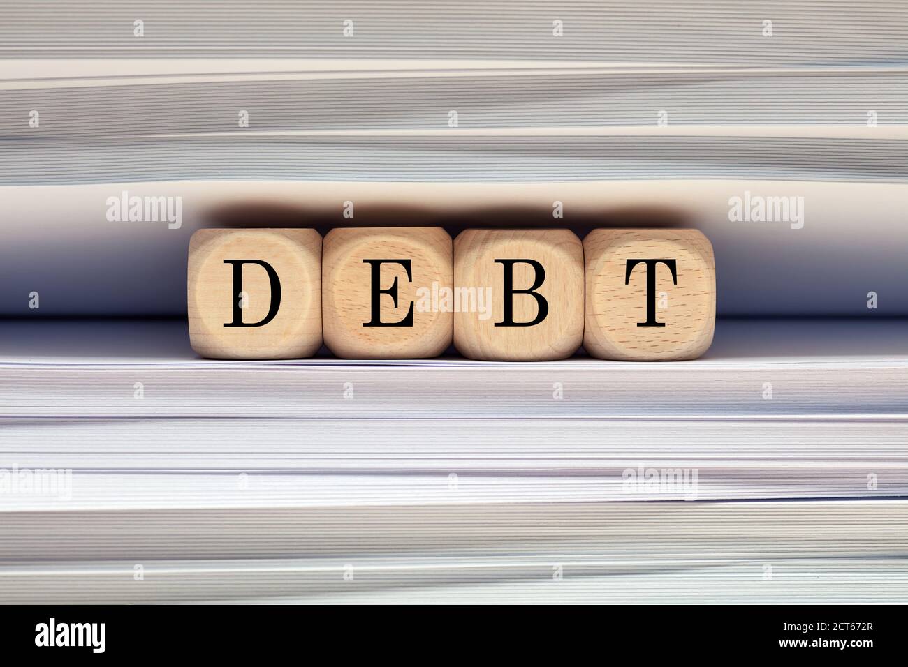 Das Wort Schulden gegen Papierakten und Ordner Hintergrund. Erhöhung der Verschuldung oder Wachstum im Geschäfts- und Finanzkonzept. Stockfoto