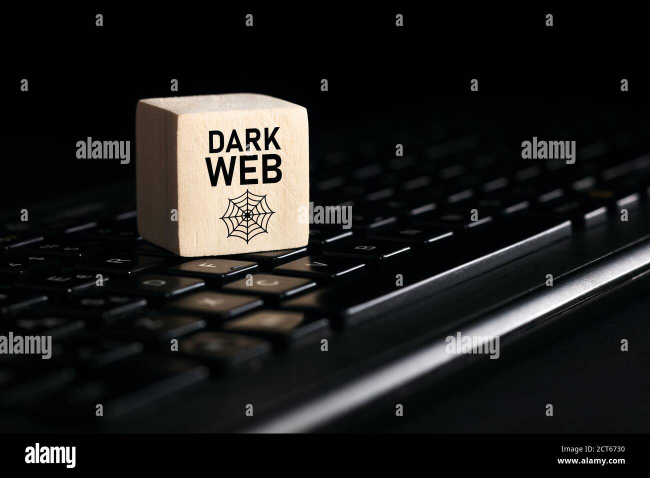 Das Wort dunkles Netz auf Holzwürfel mit Computertastatur vor schwarzem Hintergrund. Cyberkriminalität und illegale Verkaufsstellen im Cyberspace oder in der Internettechnologie Stockfoto