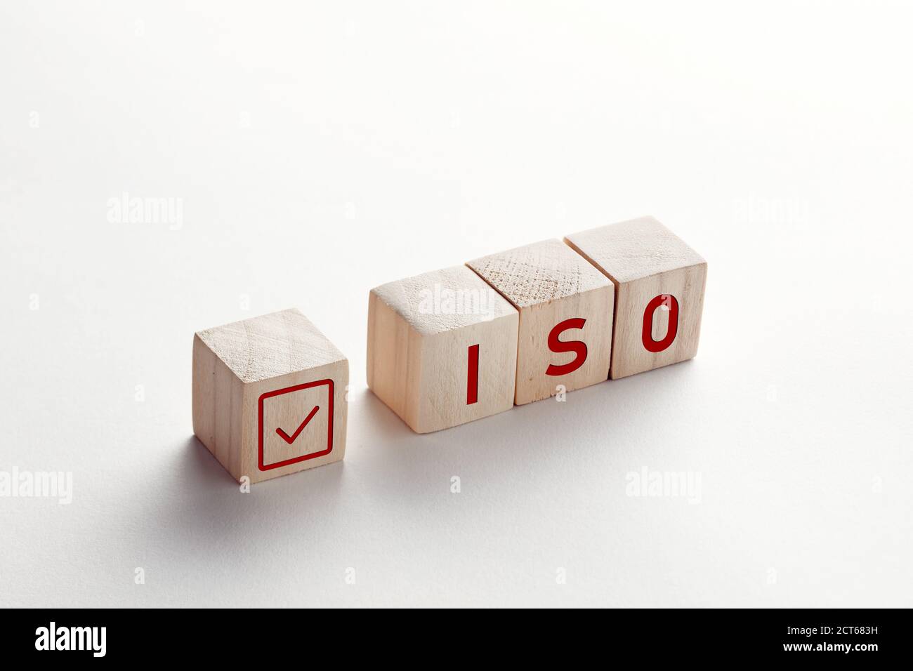 Die Abkürzung ISO auf Holzwürfeln mit Häkchen auf weißem Hintergrund. ISO Qualitätskontrolle Zertifizierung Zulassungs Konzept. Stockfoto