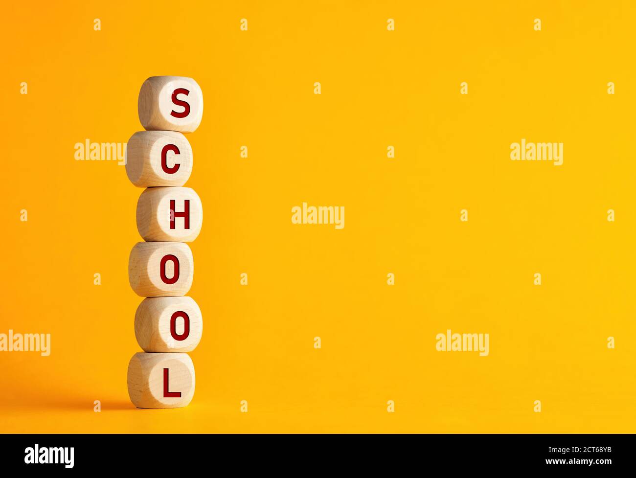 Die Wortschule auf Holzwürfeln vor gelbem Hintergrund. Bildung, zurück in die Schule und Lernkonzept. Stockfoto