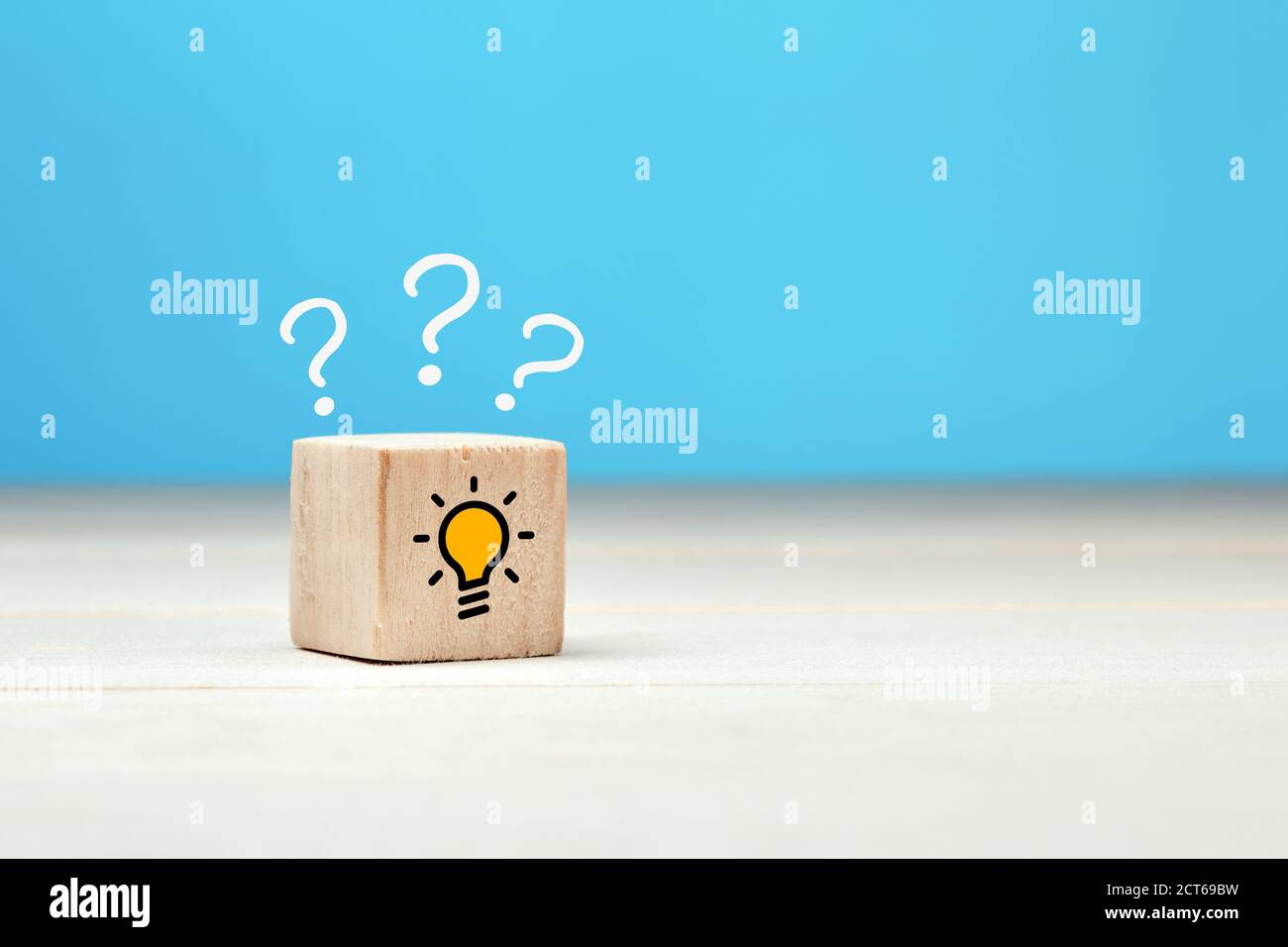 Kreative Idee, Lösung oder Problemlösungskonzept. Fragezeichen und Glühbirne Symbole auf Holzwürfel auf blauem Hintergrund. Stockfoto