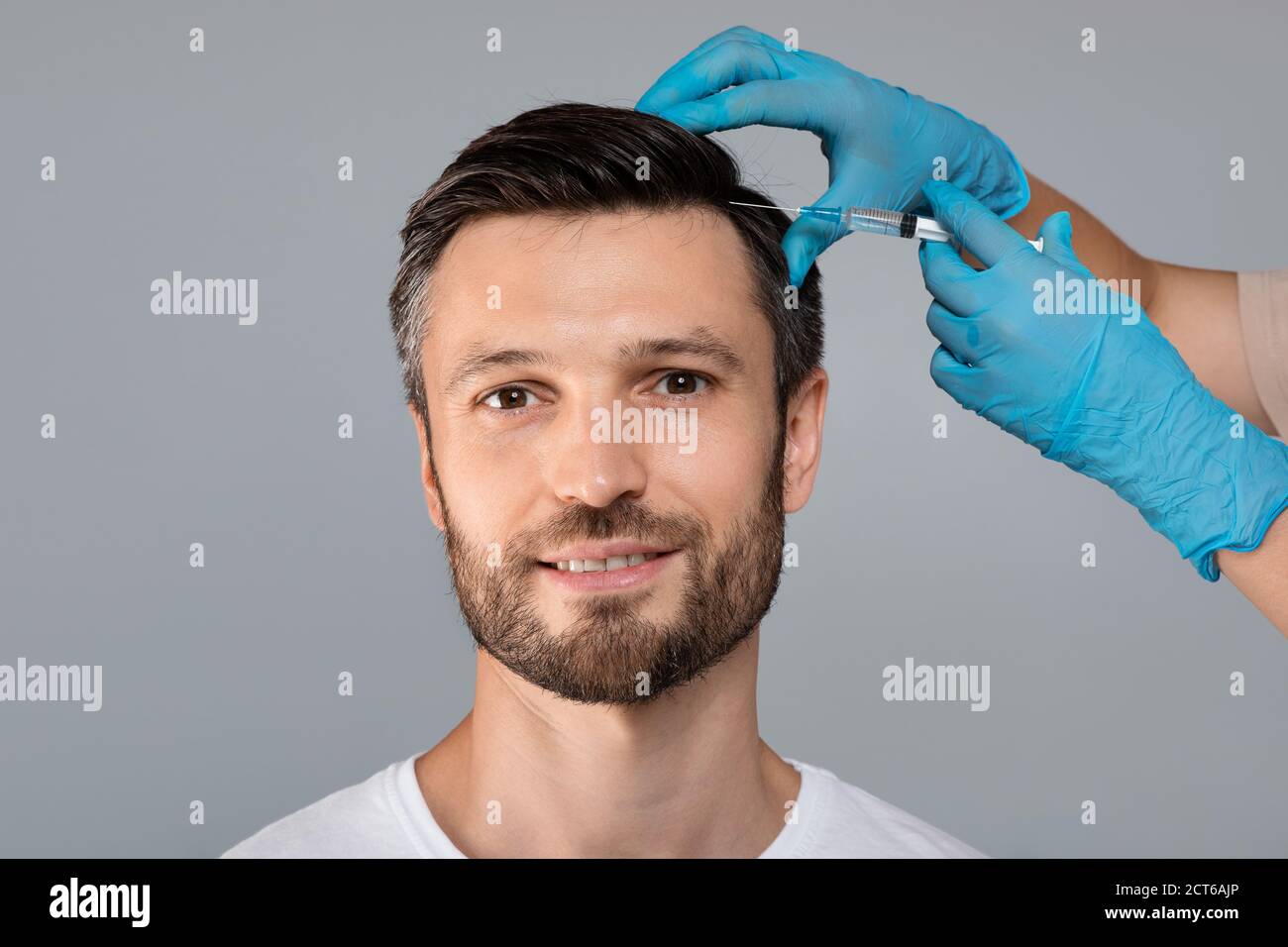 Schöner Mann mit Haarbehandlung im Salon Stockfoto