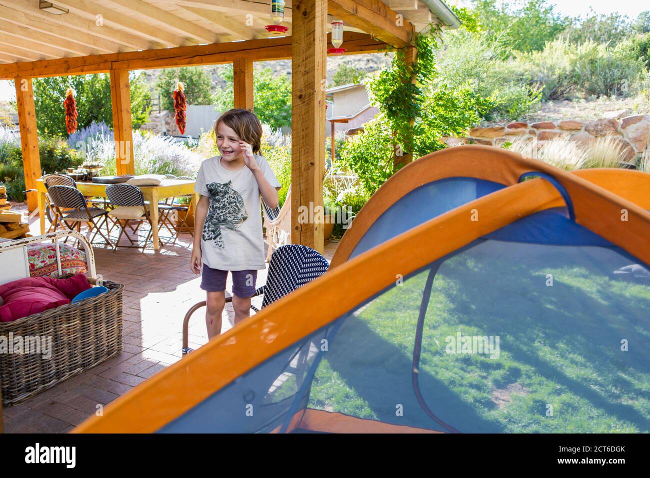 Kleiner Junge, der Zelt in einem Garten aufstellt, für einen Schlaf-Aufenthalt. Stockfoto