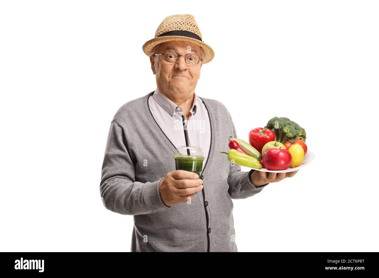 Glücklicher älterer Herr hält einen Teller mit frischem Obst und Gemüse und ein grüner Smoothie isoliert auf weißem Hintergrund Stockfoto
