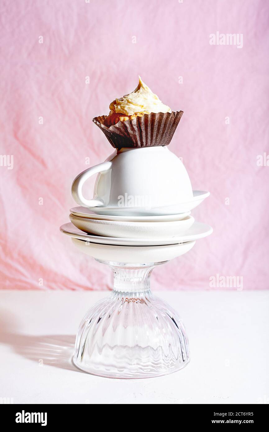Vanille Cupcake mit Schlagsahne auf rosa Hintergrund. Teatime-Konzept Stockfoto