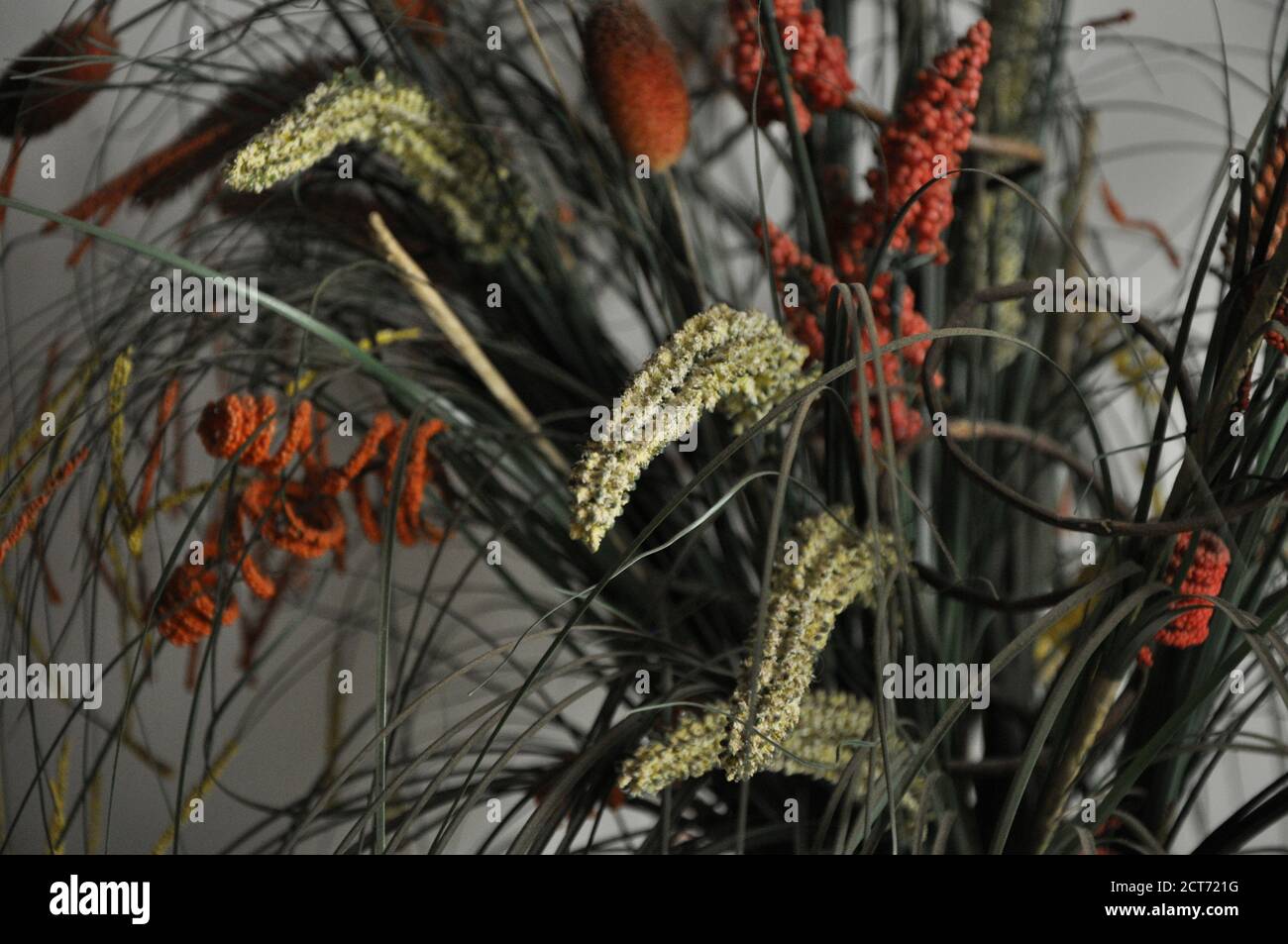 Blumenarrangement. Anordnung von bunten, unnatürlichen Blumen in Keramikvase, mit selektivem Fokus und verschwommenem Hintergrund, Foto-Zoom Stockfoto